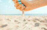 128638057-female-hand-pours-sand-on-coastline-beach-summer-vacations.jpg